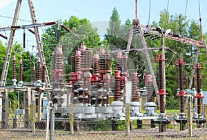 A small electrical transformer station in the open air. Ceramic insulators and wires for high voltage. Power lines. Electrical net