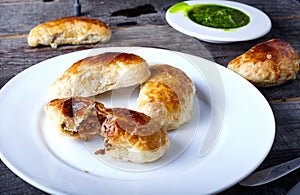 Small empanadas with meat on a white plate