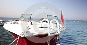 Small empty boat bobbing on waves, tied to pier