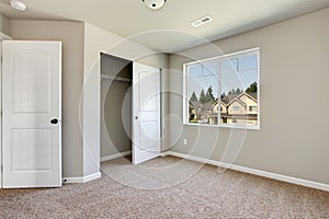 Small empty room with window and carpet floor.