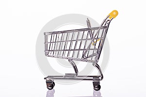 Small empty shopping cart isolated on white background. E-commerce, copy space