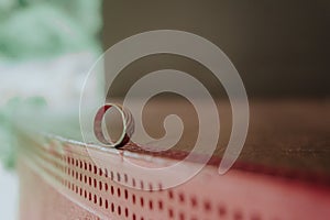 Small engagement golden ring on red surface photo