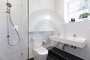 Small ensuite bathroom with white tiling laid in brick pattern