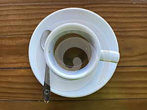 A small espresso coffee cup on a wooden table inside a local coffee house in the heart of Lisbon. Background concept for coffee