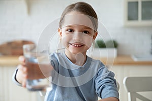 Small european child girl offering glass with fresh aqua.