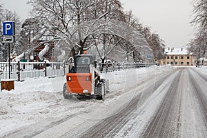 Small excavator bobcat working on the street