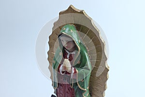 Small Figure Statue of Blessed Virgin Mary in Roman Catholic Church on white background.
