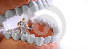 Small figure worker cleaning tooth model as medical and healthcare concept, Regular checkups are essential to oral health