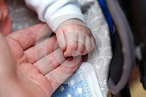 Small fingers, hands of a newborn baby in a man`s hand close-up . small depth of focus area