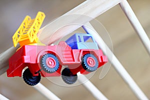 Small fire truck kids toy on a wooden baby cot