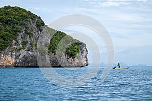 Small fisherman boat near the rock island