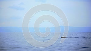 A small fisherman boat is sailing in Toba Lake, North Sumatra, Indonesia.