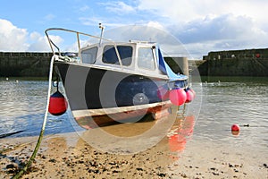 Small fishing boat on beach in harbour