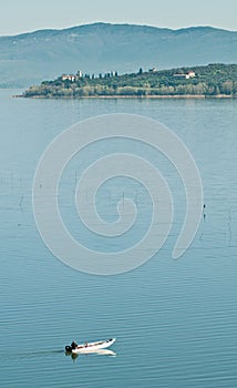 Small fishing boat crossing lake