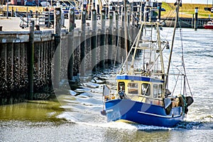 A small fishing boat enters the harbour of BÃ¼sum in North Frisia in Germany