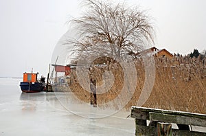 Small fishing boat on the frozen bay