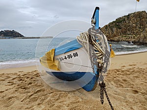 Small fishing boat moored on the beach on a cloudy day