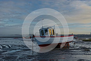 Small fishing boat on mudflats. Fragile eco-system