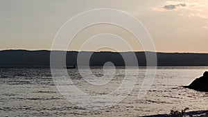 A small fishing boat in the open water of the lake. Fishing and trawling in the fishing industry