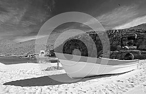 Small fishing boat / ponga at Punta Lobos beach on the coast of Baja California Mexico - black and white photo