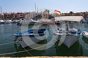 Small fishing boats moored against the harbor wall, in southern Spain, in the summer.