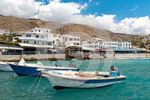 Small fishing motorboats in blues lagoon of Chora Sfakion town, Crete island, Greece.