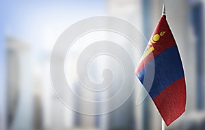 A small flag of Mongolia on the background of a blurred background photo