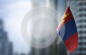 A small flag of Mongolia on the background of a blurred background photo