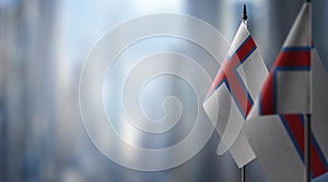 Small flags of the Faroe Islands on an abstract blurry background