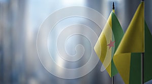 Small flags of the French Guiana on an abstract blurry background