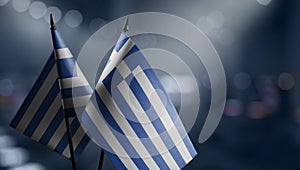 Small flags of the Greece on an abstract blurry background