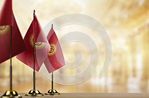 Small flags of the Kirghizia on an abstract blurry background