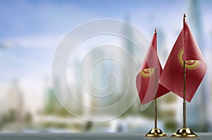 Small flags of the Kirghizia on an abstract blurry background