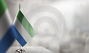 Small flags of the Sierra Leone on an abstract blurry background