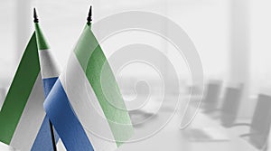 Small flags of the Sierra Leone on an abstract blurry background