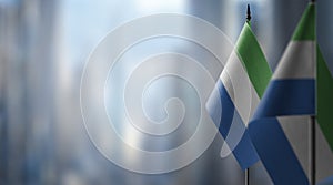 Small flags of the Sierra Leone on an abstract blurry background