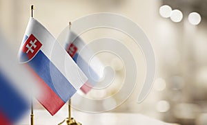 Small flags of the Slovakia on an abstract blurry background