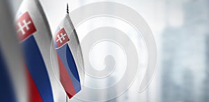 Small flags of Slovakia on a blurry background of the city