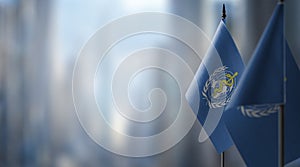 Small flags of the World Health Organization WHO on an abstract blurry background