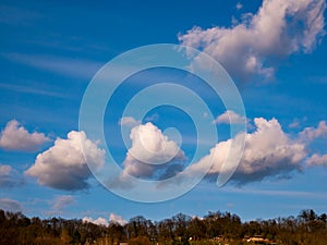 Small fluffy clouds over the horizon in the blue sky