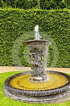 Small fountain in Versailles gardens outside Paris, France