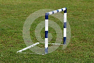 Small freshly painted blue and white metal goal post without back net used for children soccer practice at local playground