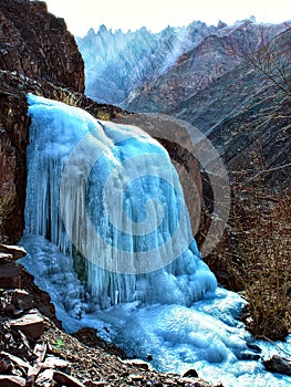 Small frozen mountain waterfall close-up