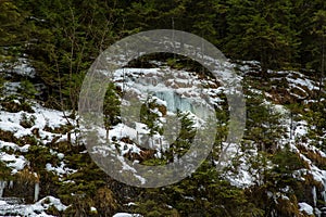 Small frozen waterfalls in the mountains in forest, Slovakia