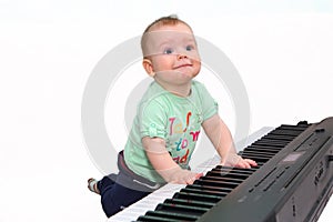 Small funny boy playing electric piano