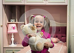 Small, funny girl with toy beart