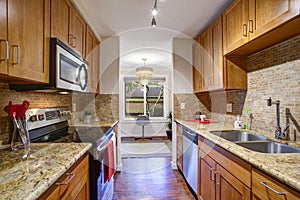Small galley kitchen design with black kitchen appliances photo