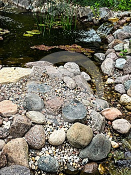 Small garden pond surrounded by colorful rocks