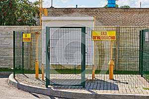 A small gas distribution station behind the fence. The inscription on the sign - `gas is flammable