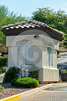 Small gaurd tower or building with visible windows and adobe roof tiles in afternoon sun with white stucco exterior photo